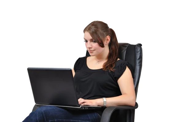 Jeune femme assise sur une chaise avec un ordinateur portable Photo De Stock