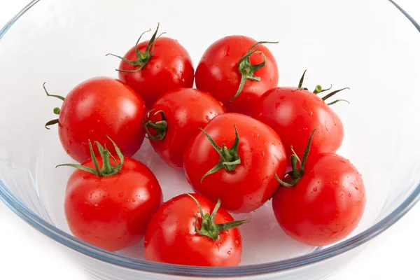 Tomater i en glasskål på en vit bakgrund — Stockfoto