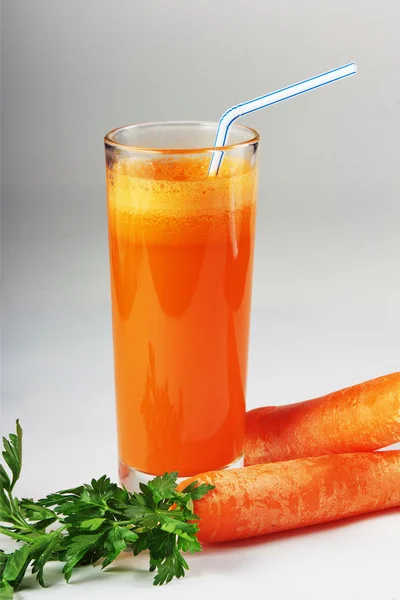 Copo de suco de cenoura e cenouras frescas isoladas em branco — Fotografia de Stock