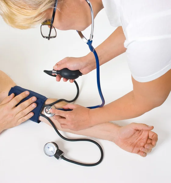 Médico mede a pressão arterial — Fotografia de Stock