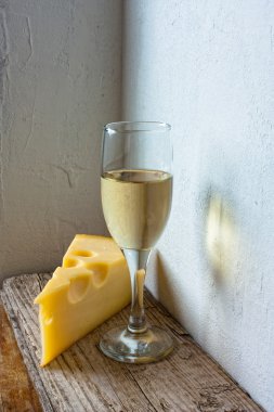 bir kadeh şarap ve peynir arka duvarda