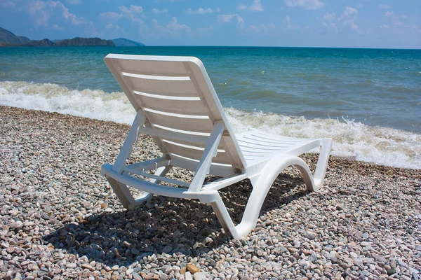 stock image White chaise lounge on the beach