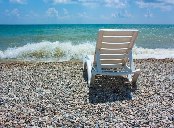 stock image White chaise lounge on the beach