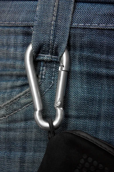 Carabiner with a rope fastened to the jeans — Stock Photo, Image