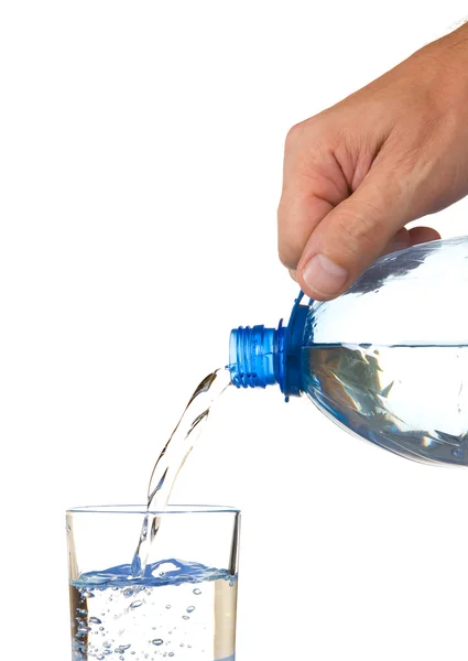 Water uit een fles in een glas gieten — Stockfoto