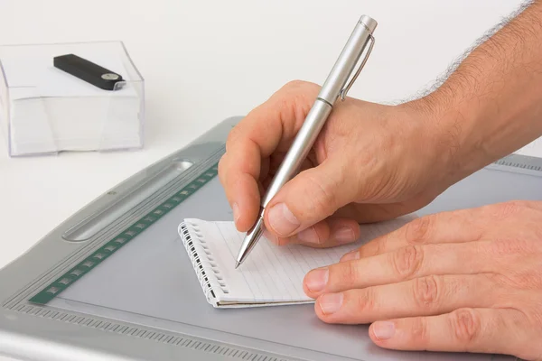 Skriva med en penna i en anteckningsbok — Stockfoto