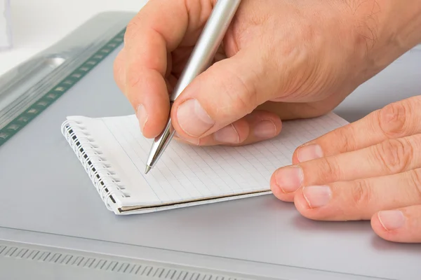 Escreva com uma caneta em um caderno — Fotografia de Stock