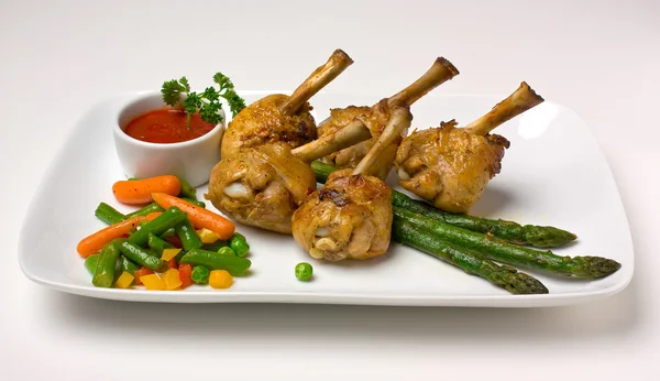 Chicken legs with asparagus and ketchup — Stock Photo, Image