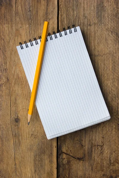 Notepad and pencil on the background of the wooden planks — Stock Photo, Image