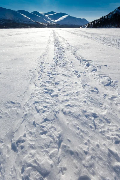 Windblown sneeuwscooter tracks — Stockfoto