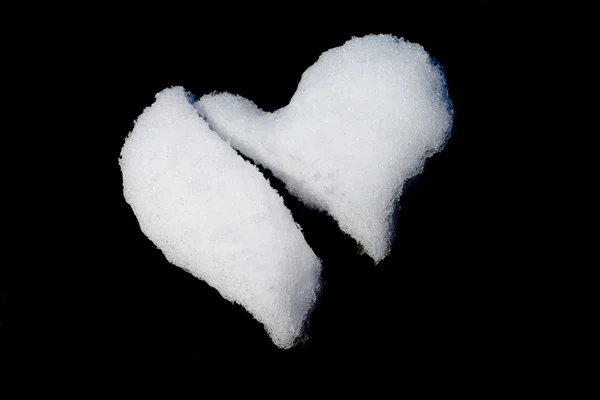 Corazón roto hecho de nieve aislado en negro — Foto de Stock