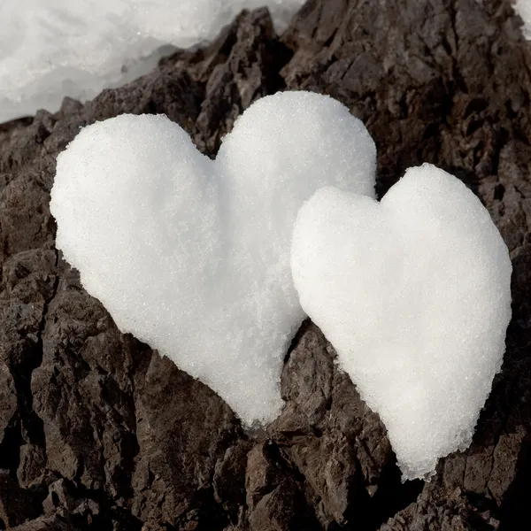 stock image Two snow hearts on rock