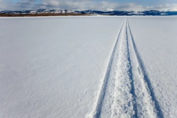 凍った湖の上スノーモービル トラック — ストック写真