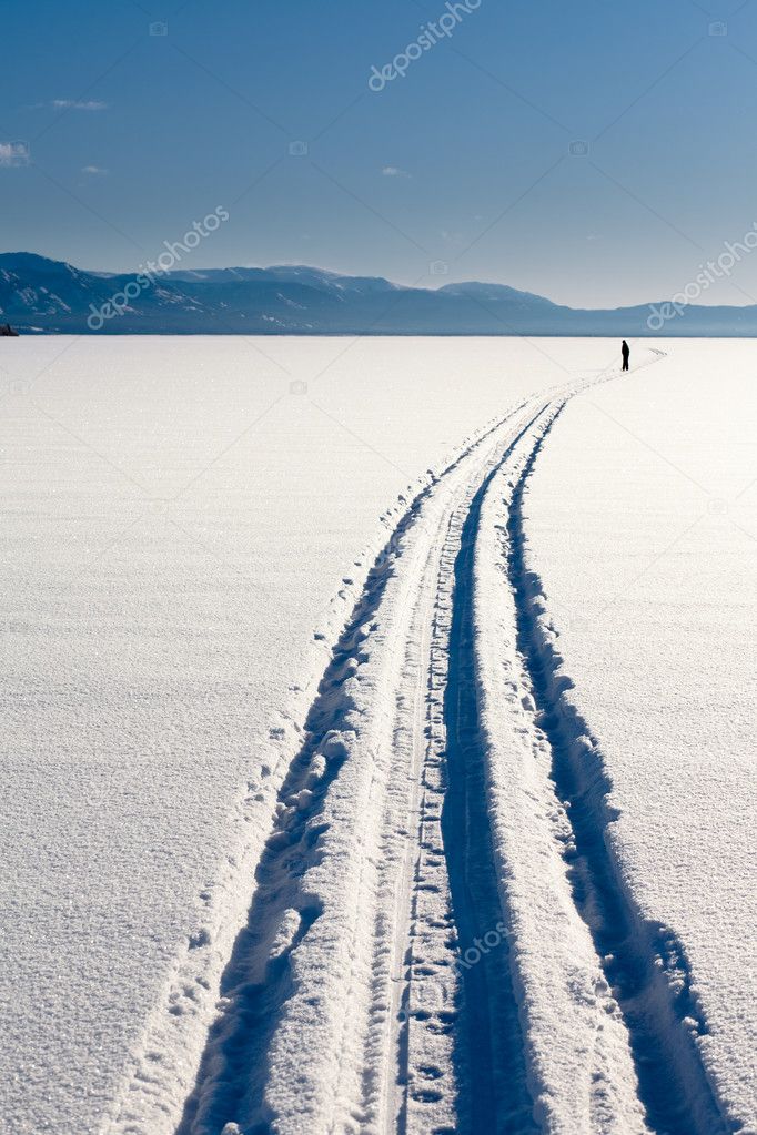 Skiing person on frozen lake