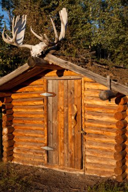 Log cabin with moose antler clipart