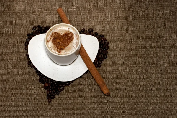 Coffee with heart and cinnamon on hessia — Stock Photo, Image