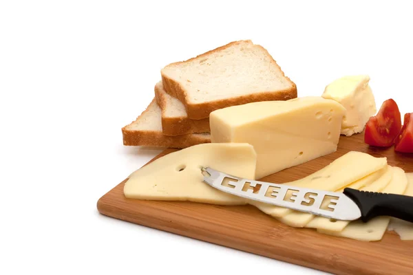 Dilimlenmiş peynir tereyağı domates ve gemide bıçak — Stok fotoğraf
