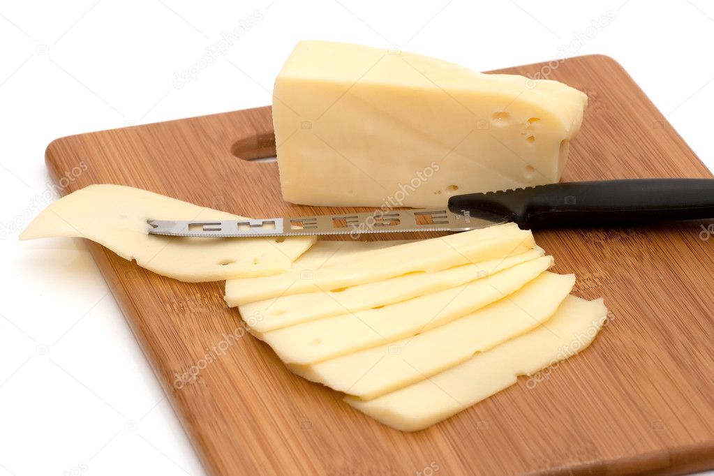Sliced cheese and knife on board