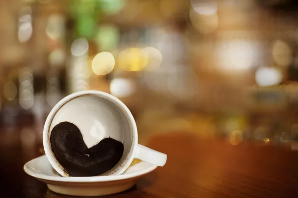 Kopje koffie met hart van koffie gronden op bar — Stockfoto