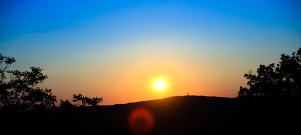 太陽と木や山の siluet と素晴らしいサンセット — ストック写真