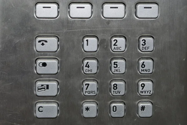 Almofada de números metálicos em um telefone público — Fotografia de Stock