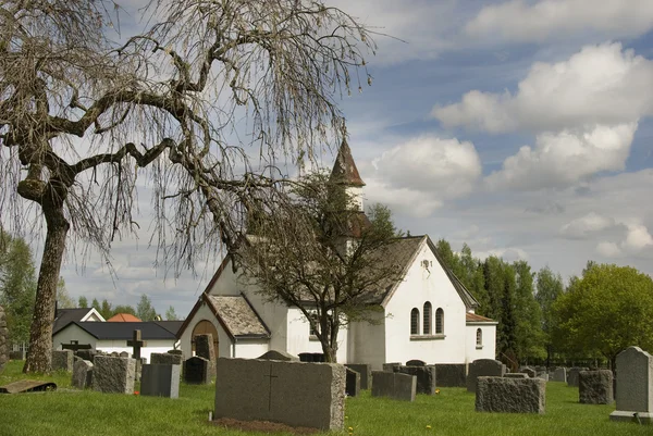 Antieke witte kerk op oude begraafplaats. — Stockfoto