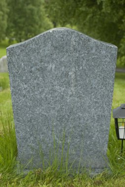 Blank tombstone stands in a cemetery. clipart