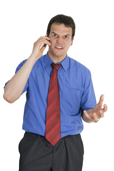 Angry young businessman talking on mobile phone — Stock Photo, Image