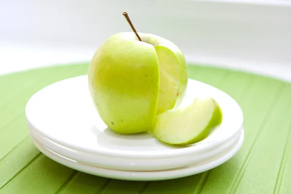 Närbild av grönt äpple och en skiva — Stockfoto