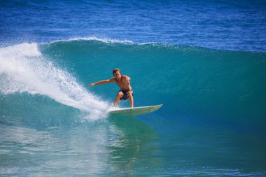 Young man surfing at Point Panic, Hawaii clipart