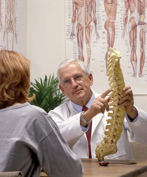 Chiropractor in zijn kantoor met patiënt — Stockfoto