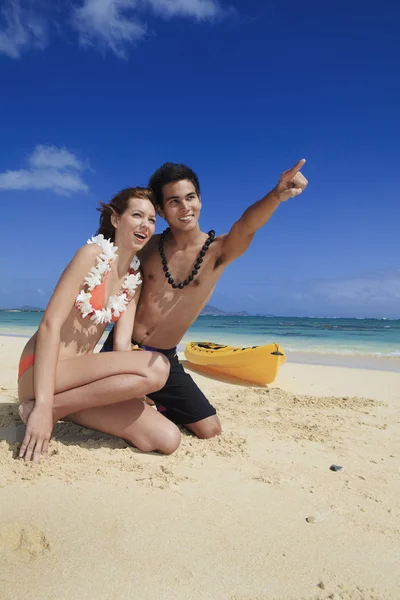 Пара на пляже на Гавайях, указывающая — стоковое фото