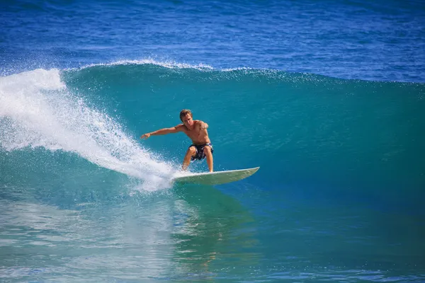 Молодой человек, занимающийся серфингом в Point Panic, Гавайи Лицензионные Стоковые Фото