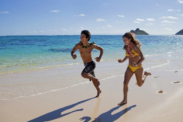 Mladý pár běží na pláži — Stock fotografie