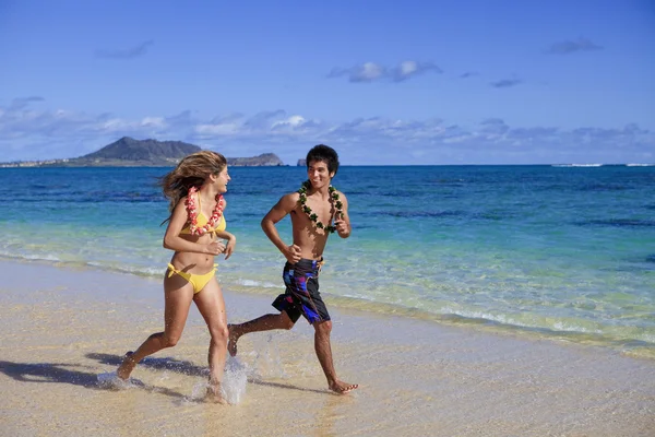 해변에서 뛰고 있는 젊은 부부 — 스톡 사진