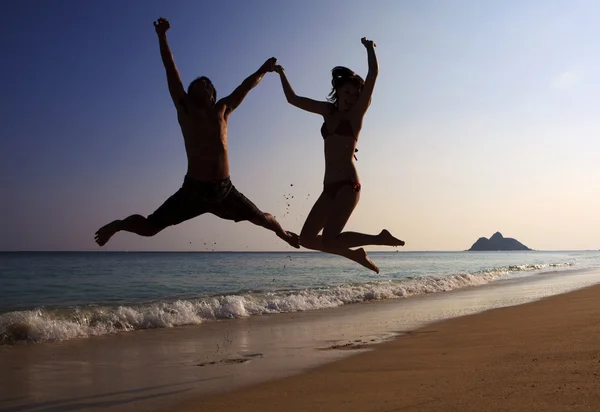 Silhouette of couple jumping — Stock Photo, Image
