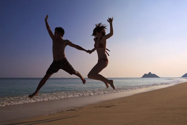 Silhouette of couple jumping — Stock Photo, Image