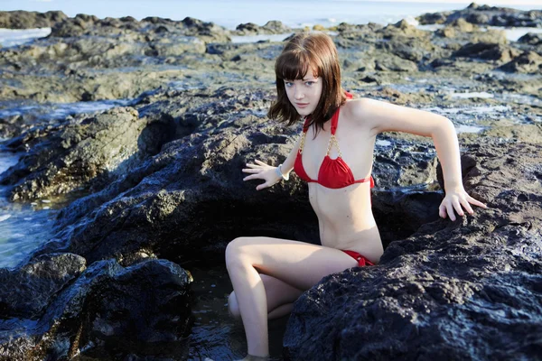 Mujer joven sentada sobre rocas de lava —  Fotos de Stock