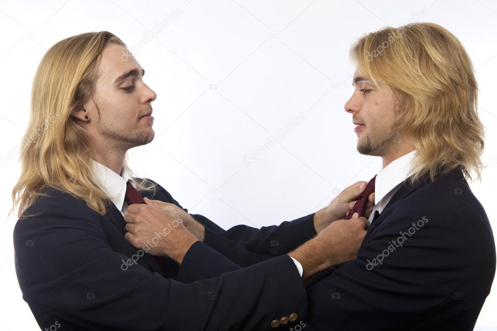 Twin brothers straightening their ties