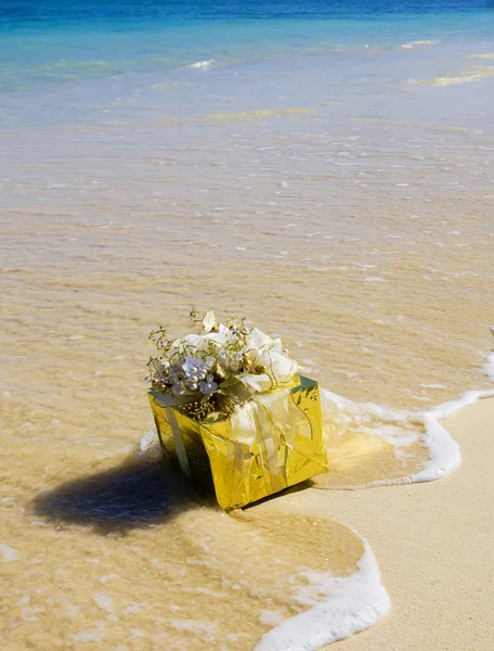 Un regalo brillantemente envuelto flota a la orilla — Foto de Stock