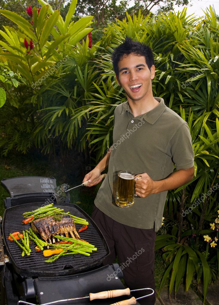 Young Asian American man grilling lamb chops — Stock Photo