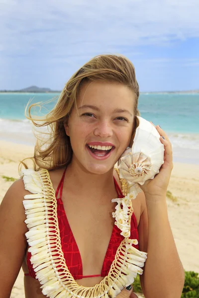 Linda adolescente escuchando una concha de mar — Foto de Stock