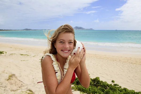 Pretty teenage girl listening to a seashell — Stock Photo, Image