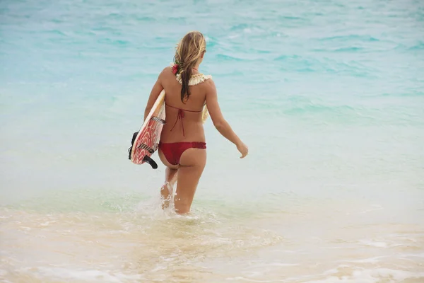 Meisje in de oceaan met haar surfboard — Stockfoto