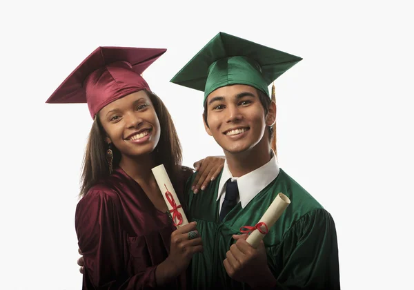 Multi racial couple in cap and gown Royalty Free Stock Photos