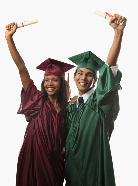Multi racial couple in cap and gown Stock Picture