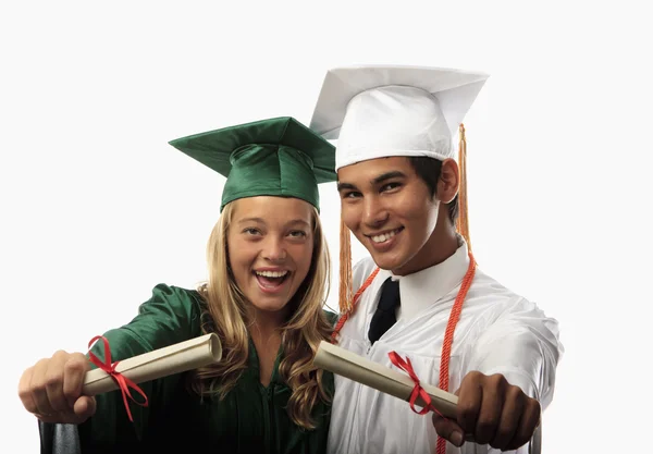 Two graduates in cap and gown Royalty Free Stock Images