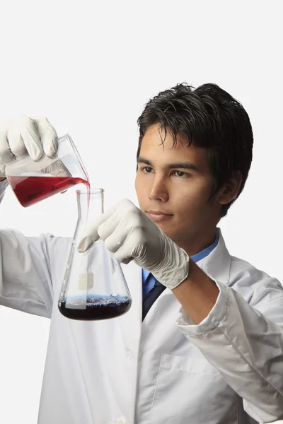 Técnico de laboratório com copo e frasco — Fotografia de Stock