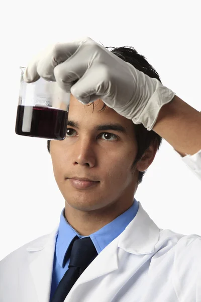 Лаборант держит стакан — стоковое фото