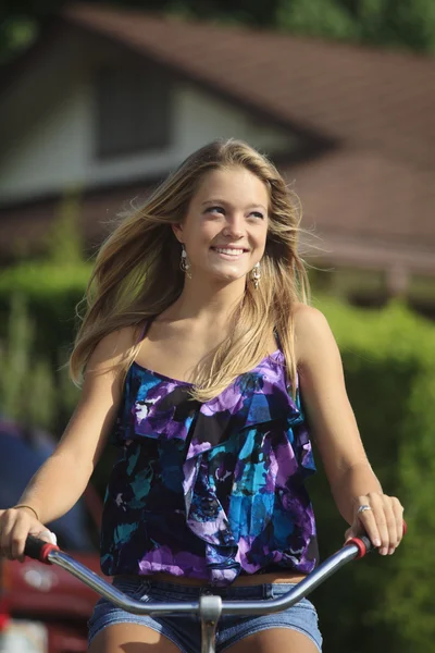 Pretty blond teenage girl rides her bicycle — Stock Photo, Image